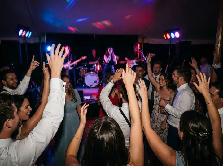 Guests dancing with their hands up in front of the band